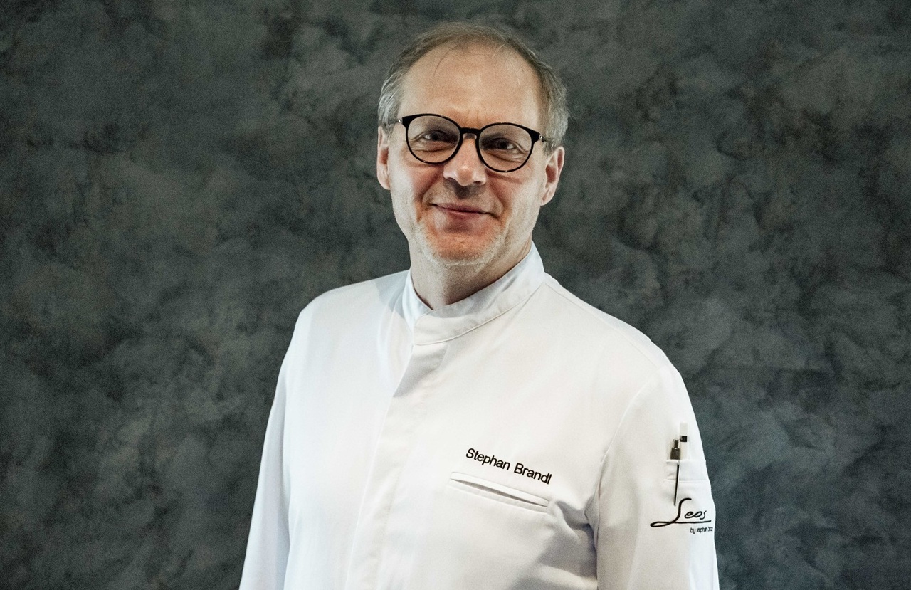 Küchenchef in weißer Kochjacke vor Backsteinwand im Bayerwaldhof